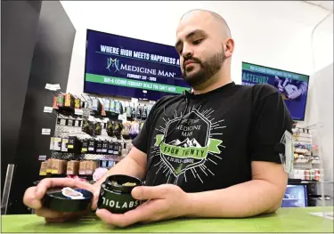 ?? PHOTOS BY CLIFF GRASSMICK — STAFF PHOTOGRAPH­ER ?? Jalen Davenport shows some of his marijuana product at Medicine Man in Longmont on Friday.