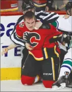  ??  ?? The Canadian Press Calgary Flames forward Michael Ferland fights with Kevin Bieksa of the Vancouver Canucks during NHL playoff action in Calgary, Sunday.