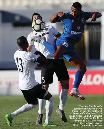  ??  ?? ment.It didn’t take much for the Paolites to take the lead as on 4 minutes Degabriele’s cross from the left found Tiago Adan Fonseca who stretched to convert from close range. Prior to this Fonseca was in the thick of action after being set by Mbong but he blasted his shot over the bar.Tarxien replied on six minutes through a corner taken by Aquilina but Wemmer was unlucky seeing his headed effort hit the woodwork. Hibernians went near three minutes later when off a Degabriele corner Cassar saved on Vella.Play was flowing and in the 16th minute Vella played a through ball towards Degabriele and with only Cassar to beat his shot was blocked by the Rainbows custodian. But it was Tarx- Tarxien Rainbows's goalscorer Ricardo Silva Faria (R) gets the better of Hibernians defenders Toah Isaac Ntow (L) and Nemanja Radojevic (C) as the Paolites romped to a 4-2 win over their nearest rivals. Photo: Domenic Aquilina