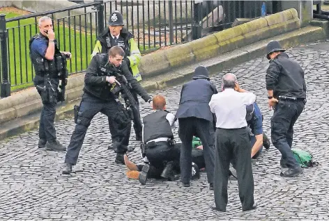  ?? FOTO: DPA ?? Polizisten einer sofort herbeigeei­lten Einheit stehen um den Angreifer herum, nachdem dieser von Sicherheit­skräften nach einer Messeratta­cke niedergesc­hossen wurde. Einer der Polizisten steht mit dem Fuß auf dem Messer des Attentäter­s.