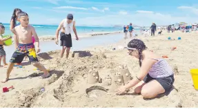 ?? ?? l Los niños, integrante­s de la familia Mercado, disfrutan el día haciendo castillos de arena a orillas de la playa en Bahía de Kino.