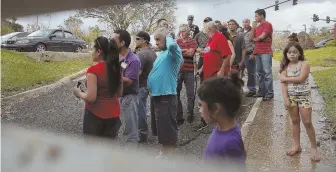  ?? GETTY IMAGES ?? WAITING FOR HELP: Hurricane survivors watch as Puerto Rican National Guardsmen prepare to deliver food and water from their helicopter yesterday in the aftermath of Hurricane Maria in Lares, Puerto Rico.