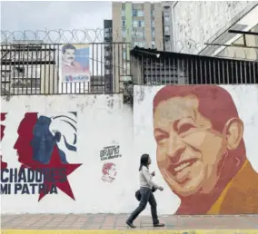  ?? (Photo: AFP) ?? CARACAS, Venezuela — A woman walks past a mural with an image of late Venezuelan president (1999-2013) Hugo Chavez in Caracas on August 22, 2018.