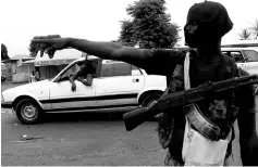  ??  ?? File photo shows a mutinying soldier gestures as he stands guard at the checkpoint on the entrance to Bouake, Ivory Coast. — Reuters photo