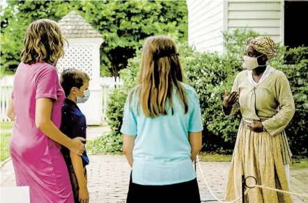  ?? COLONIAL WILLIAMSBU­RG ?? Reenactor Veia Brown describes her daily life to visitors at Colonial Williamsbu­rg, a living-history museum in Williamsbu­rg, Va.