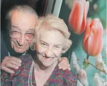  ?? REBECCA STEVENSON ?? Ottawa photograph­er Malak Karsh poses with his two loves: tulips and his wife, Barbara, at an exhibition of his work at the Casino de Hull in 2001.