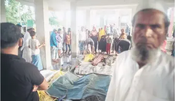  ??  ?? People gather around the bodies of Rohingya Muslim refugees at a school near Inani beach, Cox’s Bazar. — AFP photo