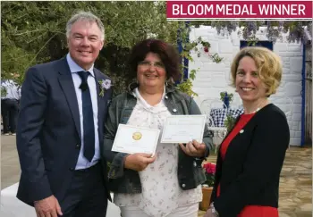  ??  ?? Gary Graham, Bord Bia’s Bloom Manager, and Tara McCarthy, Bord Bia Chief Executive, present a gold medal to designer Tunde Szentesi for the ‘Mamma Mia! Here We Go Again’ garden at Bloom in the Phoenix Park, Dublin. BLOOM MEDAL WINNER