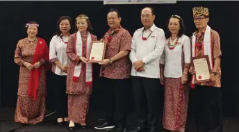  ?? ?? Nanta (centre) presents a certificat­e to Datin Sri Mariam Iboh Balan, an 80-year-old veteran who has been with the PBB since 1983 and is currently the permanent advisor to the women’s section of the party’s Mulu branch.