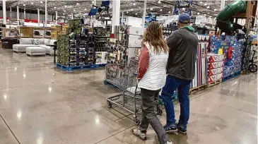  ?? ?? Shoppers pass displays of goods in a Costco warehouse on Feb. 25, in Sheridan, Colo. On Tuesday, the Conference Board issued its latest monthly report on U.S. consumer confidence, which captures public responses on issues ranging from purchasing plans to the direction of inflation.