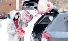  ?? CHARLES REX ARBOGAST/AP ?? Ellen Yun loads Valentine’s Day gifts for her mom, sister and brother in-laws, nephew and her two children Saturday in Chicago. This Valentine’s Day, Americans are searching to celebrate love amid the isolation and heartache of the pandemic.