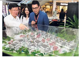  ??  ?? Business model: Chow (left) looking at a project model as Star Media Group regional operations general manager (north) Simone Liong and Zeon Properties founder and group CEO Leon Lee look on at Gurney Paragon Mall in Penang.