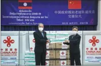  ?? XINHUA ?? Chinese Ambassador to Laos Jiang Zaidong (right) and Lao Deputy Prime Minister Kikeo Khaykhamph­ithoune take part in a handover for China-donated vaccines in Vientiane on Tuesday.