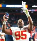  ?? AP PHOTO/DAVID ZALUBOWSKI ?? Kansas City Chiefs defensive end Chris Jones holds up his phone while walking off the field after Saturday’s 28-24 win against the host Denver Broncos.