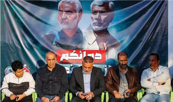  ?? AFP ?? A banner in Baghdad displays images of Iranian IRGC commander Qassem Suleimani, left, and Abu Mahdi Al Muhandis, leader of Iran-backed Iraqi militia Kataib Hezbollah, who were assassinat­ed in a US drone strike in the Iraqi capital in January 2020