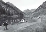  ?? Daniel Petty, Denver Post file ?? Hikers, photograph­ers and visitors gather at Maroon Lake to photograph the Maroon Bells at sunrise.