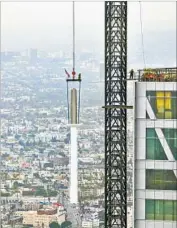  ?? Irfan Khan Los Angeles Times ?? A CRANE lifts the final segment of spire to be installed atop the Wilshire Grand tower. It is the tallest structure to be built in an active earthquake zone.