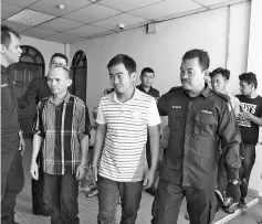  ??  ?? Sharul (second left), Zulfazly (third left), Hasnan (back second right) and Sahbeneh (back right) being led away after their sentencing yesterday.