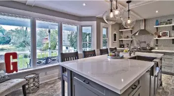  ??  ?? TOP RIGHT: Hints of history are seen throughout the house, including a stained-glass window with an image of the bridge and a vintage sewing machine. ABOVE: The kitchen is brand new and takes in a scenic view of the Grand River in the front yard.