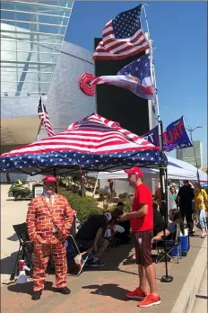  ?? AP PHOTO — TOM MCCARTHY ?? Supporters of President Trump, including a man dressed as the border wall, line up outside an arena in Tulsa, Oklahoma, June 18, 2020, where the president will hold his first campaign rally in months this weekend. Despite the heat, the ever-growing risk of coronaviru­s and a lukewarm reception from local officials, dozens of backers of Trump are already camped out outside the arena.