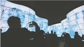  ??  ?? 今年1月，美国拉斯维加斯消费电­子展上，人们在LG展厅体验曲­面高清屏幕走廊新华社­图