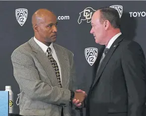  ?? Kathryn Scott, The Denver Post ?? New Colorado football coach Karl Dorrell shakes hands with athletic director Rick George on Monday at the Dal Ward Center on the CU campus. Dorrell was the surprise choice to replace Mel Tucker, now the coach at Michigan State.