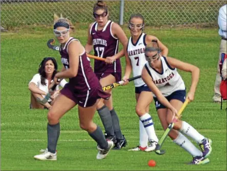  ?? PHOTOS BY DAVID M. JOHNSON - DJOHNSON@DIGITALFIR­STMEDIA.COM ?? Saratoga Springs' Lindsey Frank (4) moves with the ball as teammate Erin McCarthy (7) looks on and Burnt Hills-Ballston Lake players Erin McCleman, left, and Deirdre Rafferty (17) defend in a Suburban Council field hockey game Wednesday at Saratoga...