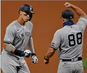  ?? AP PHOTO BY DAVID DERMER ?? New York Yankees’ Aaron Judge (99) is congratula­ted by Phil Nevin (88) after hitting a two run home run off Cleveland Indians starting pitcher Shane Bieber (57) in the first inning of Game 1 of an American League wild-card baseball series, Tuesday, Sept. 29, in Cleveland.