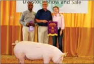  ??  ?? Champion Market Hog was purchased by GrayHawk Home Care of West Chester for $8.50/lb which was then donated to the Chester County Food Bank for use in their services. Pictured are Andrew Henderson, CEO and owner of GrayHawk, Olivia Jaekle and Larry...