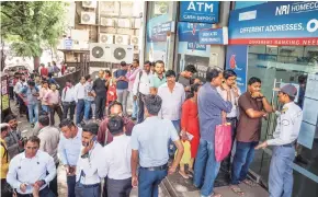  ?? PHOTO:PTI ?? Account holders gather outside a YES Bank branch to withdraw money, in Thane on Friday