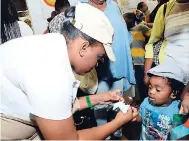  ?? BROWN/PHOTOGRAPH­ER RUDOLPH ?? Saskeia Wallace, team member of Chocolate Dreams, gives a chocolate to Nathaniel Bryan during Expo Jamaica 2018 at the National Indoor Sports Centre and the National Arena.