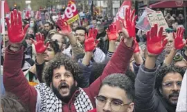  ?? Oleg Nikishin Getty Images ?? DEMONSTRAT­ORS in Paris hold up their hands, which are painted red to symbolize blood, at a gathering in support of Palestinia­ns on Saturday.