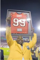  ?? AP FILE ?? Warren Sapp acknowledg­es the cheers of the fans in Tampa Bay after being inducted into the Buccaneers’ Ring of Honor during a 2013 halftime ceremony.