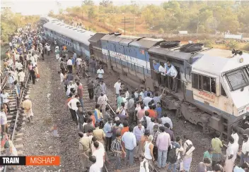  ?? — PTI ?? People gather near the site where an engine and a coach of the Puducherry- Dadar Express derailed at Unkal station near Hubli, Karnataka, on Monday.