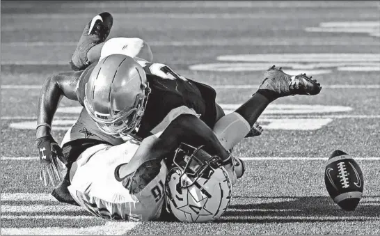  ?? NAM Y. HUH/AP ?? Notre Dame safety Jalen Elliott, top, reaches Vanderbilt wide receiver Kalija Lipscomb in time to separate him from the ball as Lipscomb tries to make a second-half catch Saturday.