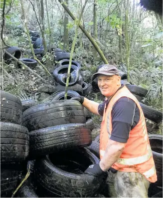  ?? Photo / Waikato Regional Council ?? DoC Waikato District biodiversi­ty and recreation/ historic supervisor Glyn Morgan cleaning up illegally dumped tyres at Te Toto Gorge near Raglan.