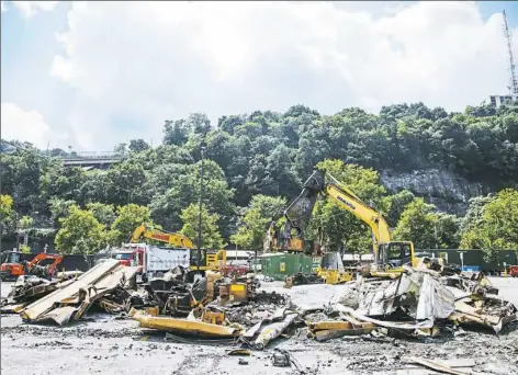  ?? Andrew Rush/Post-Gazette ?? Cleanup continues at the scene of a freight train derailment at the Station Square T Station on Thursday on the South Side.