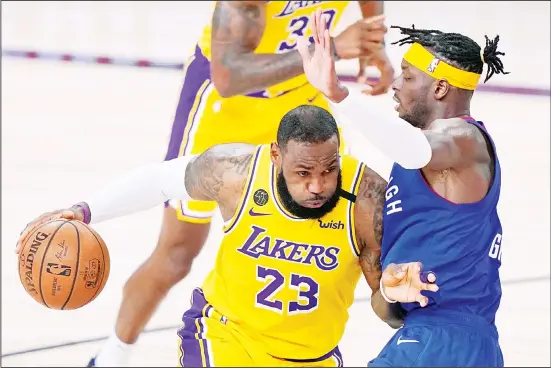  ??  ?? Los Angeles Lakers forward LeBron James (23) works against Denver Nuggets forward Jerami Grant (right), to advance the ball up court during the second half of an NBA conference final playoff
basketball game on Sept 18, in Lake Buena Vista, Florida. (AP)