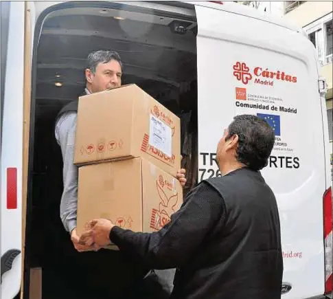  ?? Fotos: Archimadri­d / José Luis Bonaño ?? Benito y Marco Antonio recogen productos de Taller 99, la empresa de confección de Labora, para llevarlos a su tienda