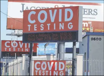  ?? Damian Dovarganes The Associated Press ?? Ads for COVID-19 testing are posted Friday outside Los Angeles Internatio­nal Airport. Doctors want to know what makes some virus patients so much sicker than others.