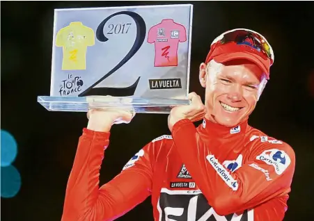  ?? — AP ?? Double joy: Britain’s Chris Froome celebratin­g on the podium after winning the Vuelta a Espana on Sunday. The special trophy he holds was given to him as he won both the Tour de France and Vuelta.