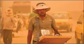  ?? ?? A street vendor sells cigarettes during a sandstorm in Baghdad.