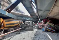  ??  ?? Vehicles are seen trapped under the collapsed overpass in Kolkata on Thursday. —