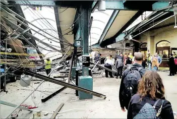  ?? AP-BILD: SAMUEL ?? Ein Pendlerzug aus New York ist am Donnerstag ungebremst in einen Kopfbahnho­f im US-Staat New Jersey gerast.Teile des Bahnhofsda­ches stürzten ein.