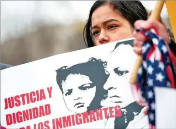  ?? ANDREW CABALLERO-REYNOLDS/AFP ?? A young girl looks on as other immigrants and activists protest near the White House to demand that the Department of Homeland Security extend Temporary Protected Status for more than 195,000 Salvadoran­s, on Monday, in Washington, DC.