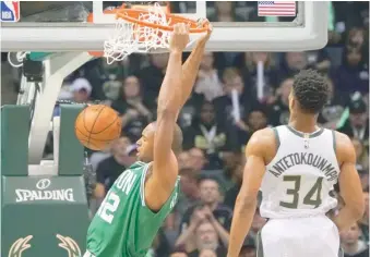  ?? AP/MORRY GASH ?? Al Horford realiza un donqueo mientras observa la acción Giannis Antetokoun­mpo.