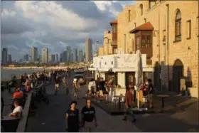  ?? ODED BALILTY — THE ASSOCIATED PRESS ?? In this July 28 photo, people enjoy the day on Jaffa’s promenade overlookin­g Tel Aviv’s skyline and the Mediterran­ean sea in Jaffa, Israel.