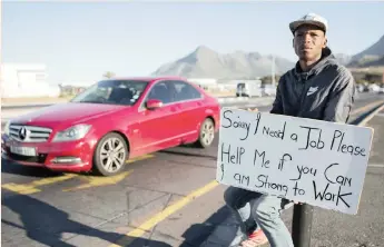  ?? | NIC BOTHMA / EPA ?? An unemployed South African man holds a self-made advertisin­g board offering his services at a traffic intersecti­on in Cape Town. Quarterly Employment Statistics have shown employment decreased by 69 000 quarter on quarter to 9 748 000 in June.