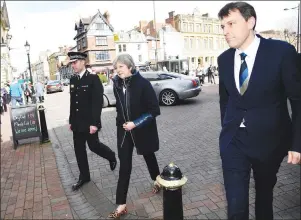 ?? AP PHOTO ?? Britain’s Prime Minister Theresa May, centre, is accompanie­d by members of the police as she views the area where former Russian double agent Sergei Skripal and his daughter were found critically ill, in Salisbury, England, Thursday.