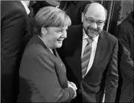  ?? BERND VON JUTRCZENKA / DPA VIA ASSOCIATED PRESS ?? Angela Merkel, German chancellor and head of the Christian Democrats, and Martin Schulz, the leader of the Social Democratic party, shake hands in Berlin on Sunday ahead of coalition talks. Angela Merkel, German chancellor